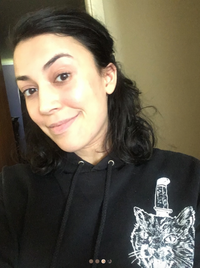 selfie of a woman in a black sweater smiling